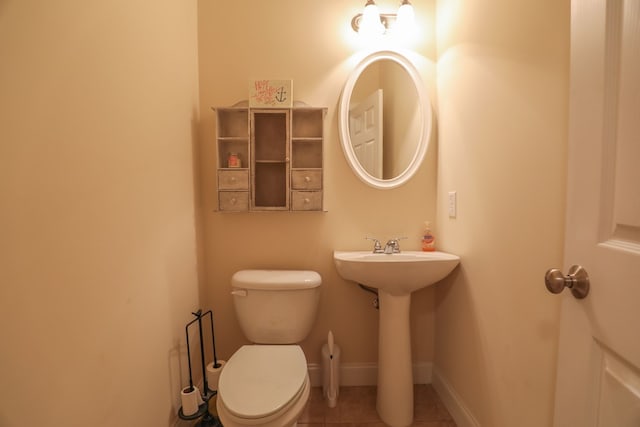 bathroom featuring tile patterned flooring, toilet, and sink