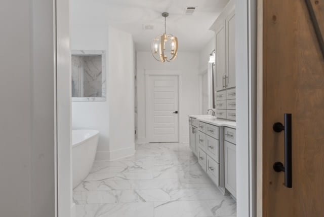 bathroom with vanity, a bathtub, and a notable chandelier