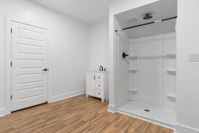 bathroom featuring hardwood / wood-style floors and walk in shower