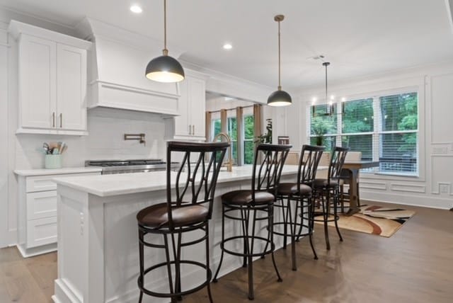 kitchen with white cabinets and an island with sink