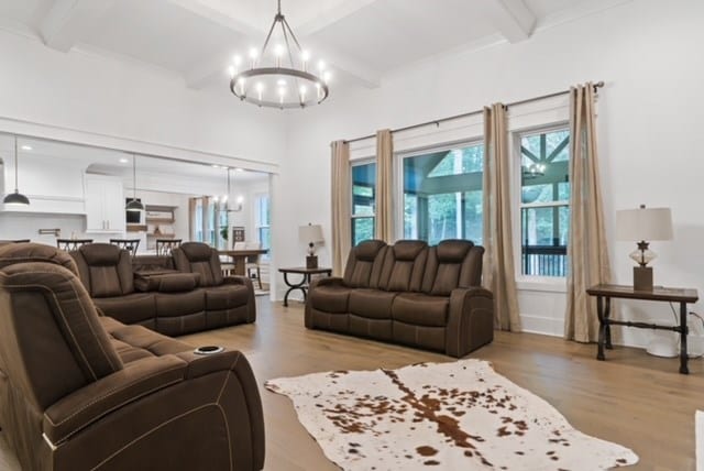 living room featuring beamed ceiling, light hardwood / wood-style flooring, and a chandelier