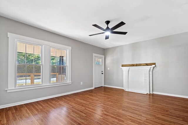 174 Main St, Toomsboro, GA 31090 - unfurnished living room featuring wood finished floors, plenty of natural light, and baseboards