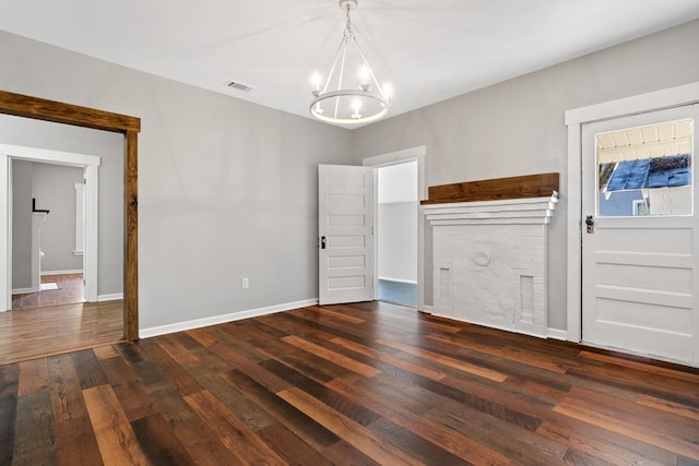 174 Main St, Toomsboro, GA 31090 - unfurnished living room featuring a chandelier, dark wood finished floors, and baseboards