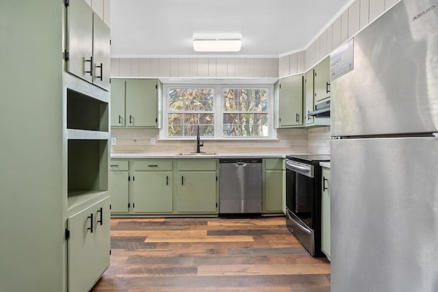174 Main St, Toomsboro, GA 31090 - kitchen with stainless steel appliances, green cabinets, a sink, tasteful backsplash, and light countertops