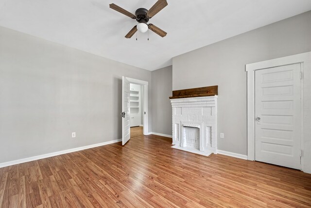 174 Main St, Toomsboro, GA 31090 - unfurnished living room with ceiling fan, light wood-style floors, baseboards, and a fireplace