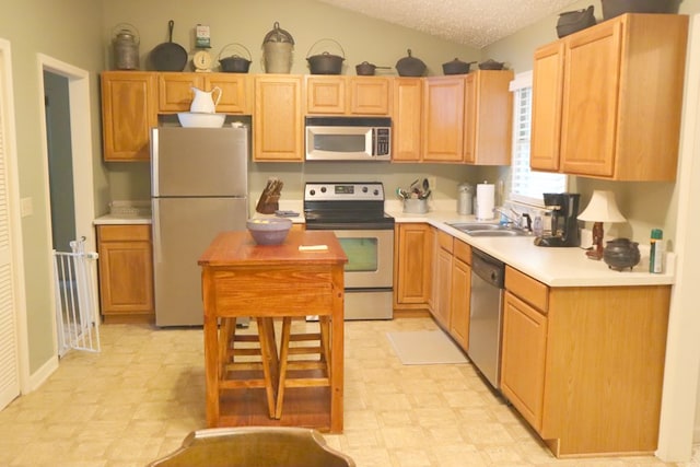 kitchen with a sink, appliances with stainless steel finishes, light countertops, and light floors