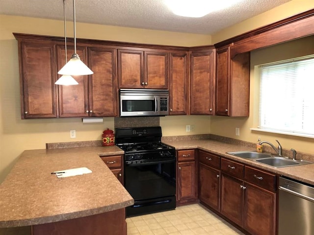 104 Wesley Ct, Eatonton, GA 31024 - kitchen featuring appliances with stainless steel finishes, hanging light fixtures, dark brown cabinets, a textured ceiling, and a peninsula