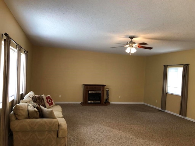 104 Wesley Ct, Eatonton, GA 31024 - unfurnished living room featuring carpet, ceiling fan, a fireplace with raised hearth, and a textured ceiling