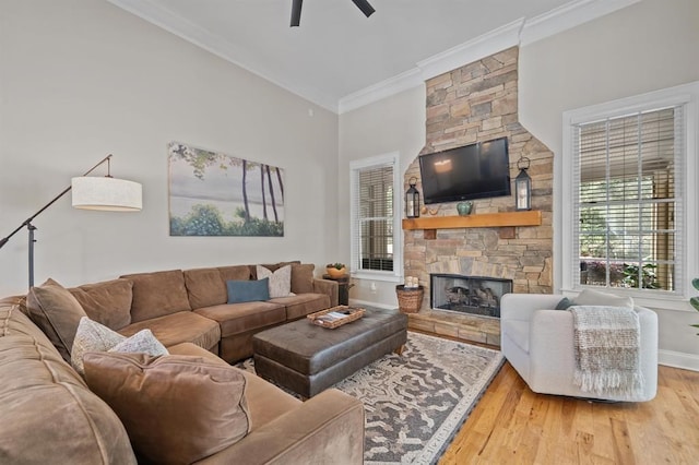 living room with crown molding, baseboards, a fireplace, wood finished floors, and a ceiling fan