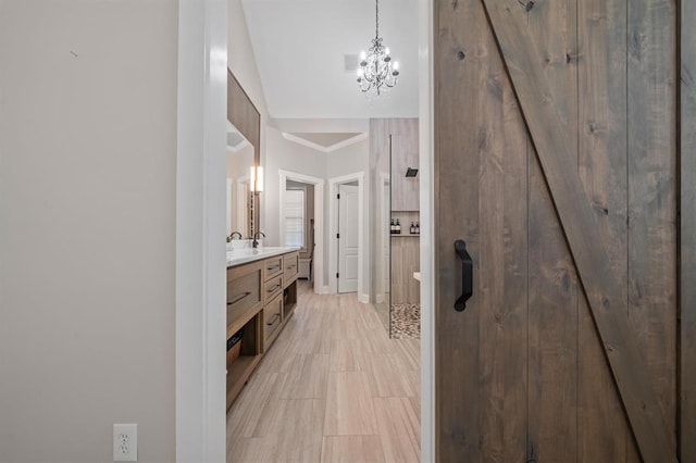 bathroom with crown molding, an inviting chandelier, vanity, and walk in shower