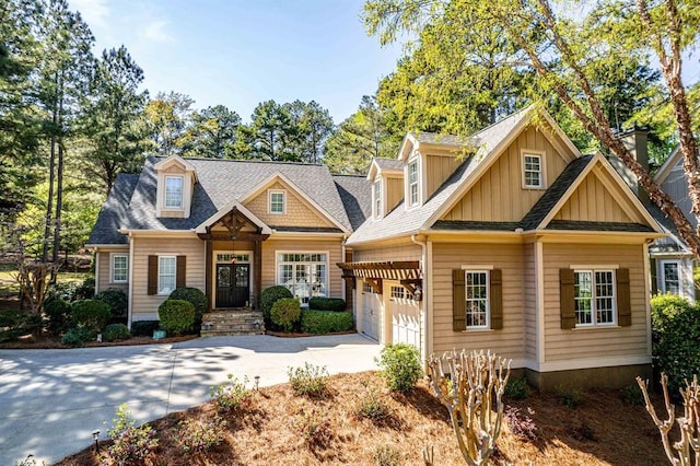 view of front of home featuring driveway, an attached garage, board and batten siding, and roof with shingles