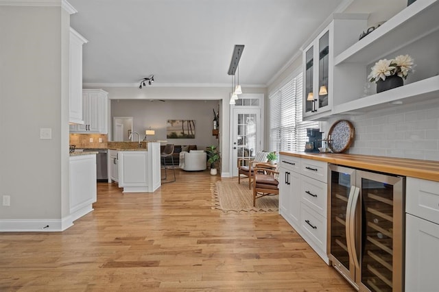 dining space with baseboards, ornamental molding, a chandelier, and light wood finished floors
