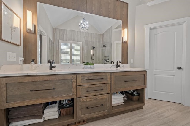 bathroom featuring double vanity, an inviting chandelier, a sink, and walk in shower