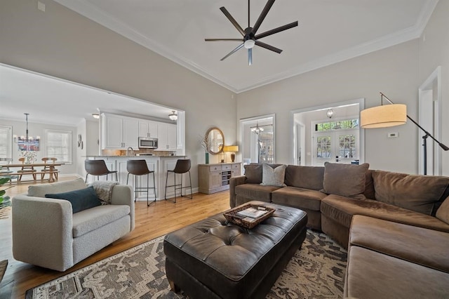 living area with crown molding, a healthy amount of sunlight, and ceiling fan