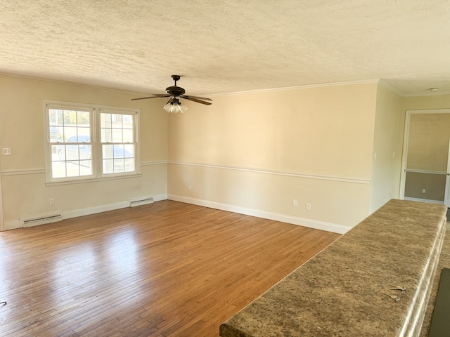 unfurnished room with a textured ceiling, a baseboard radiator, ornamental molding, ceiling fan, and hardwood / wood-style floors