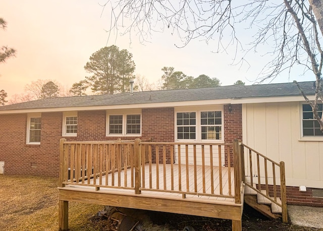 back house at dusk featuring a wooden deck