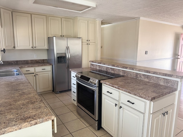 kitchen with appliances with stainless steel finishes, sink, light tile patterned floors, and a textured ceiling