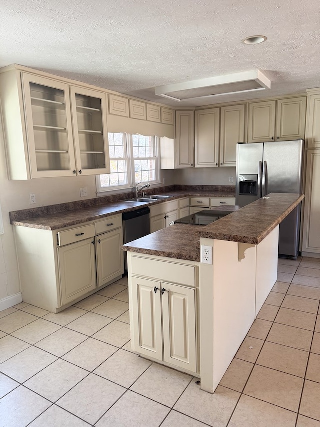 kitchen featuring light tile patterned floors, a kitchen breakfast bar, stainless steel appliances, a center island, and cream cabinets