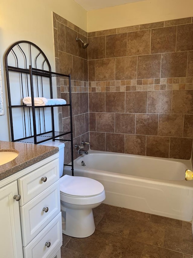 full bathroom with vanity, tiled shower / bath combo, and toilet