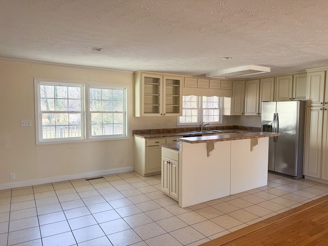 kitchen featuring a center island, a breakfast bar area, cream cabinetry, and stainless steel fridge with ice dispenser