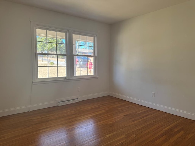 spare room featuring hardwood / wood-style flooring and plenty of natural light