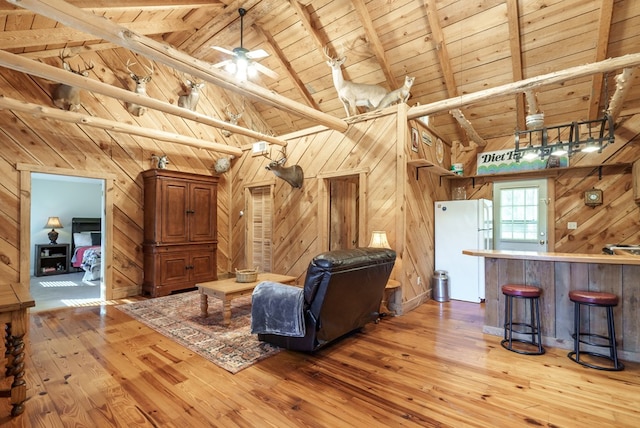 unfurnished living room with beam ceiling, wood ceiling, and wooden walls