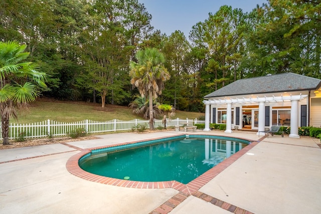 view of swimming pool featuring an outbuilding, a yard, a patio, and a pergola