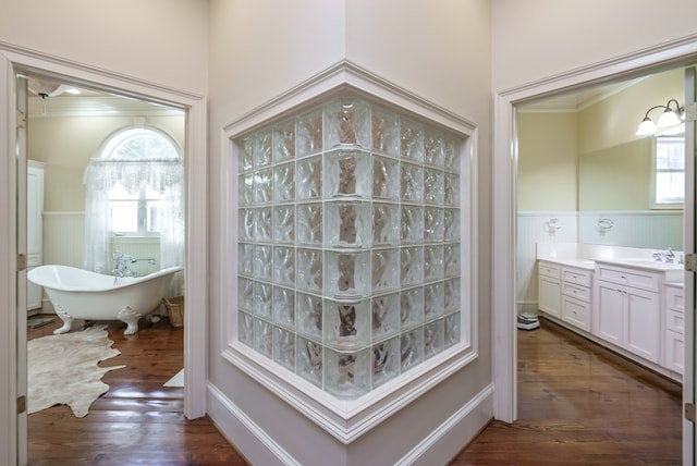 bathroom featuring hardwood / wood-style floors, vanity, crown molding, and a bath