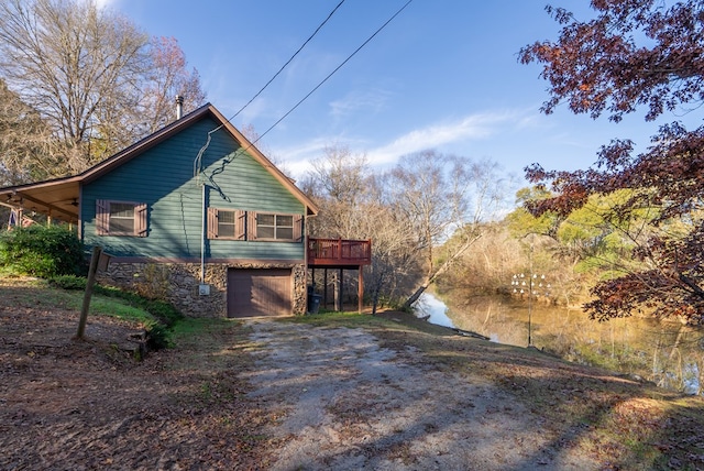 view of property exterior with a wooden deck and a garage