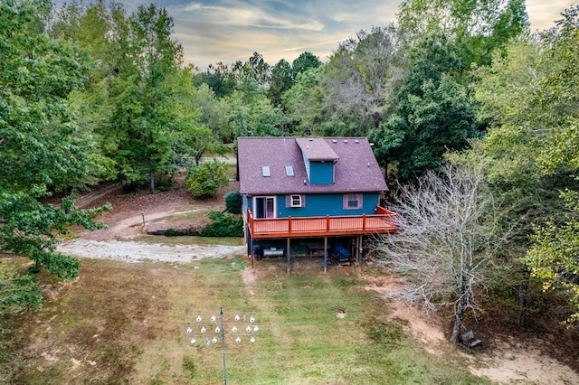 back house at dusk featuring a wooden deck