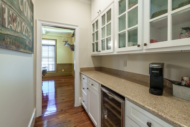 bar featuring white cabinets, wine cooler, light stone countertops, and ornamental molding