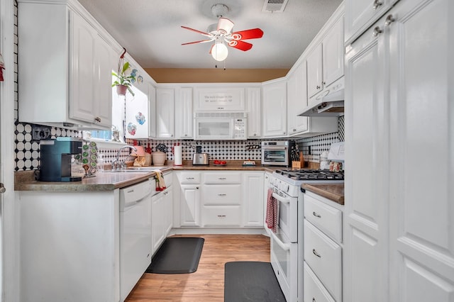 kitchen with backsplash, light hardwood / wood-style floors, a textured ceiling, white appliances, and white cabinets