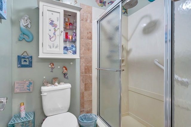 bathroom featuring a shower with shower door and toilet