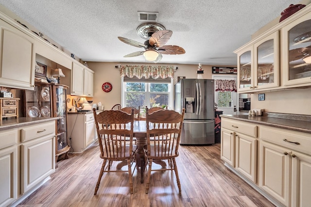 dining area with a textured ceiling, light hardwood / wood-style floors, and ceiling fan