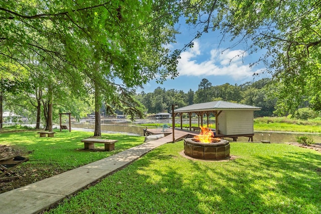 view of yard with a gazebo, a water view, and an outdoor fire pit