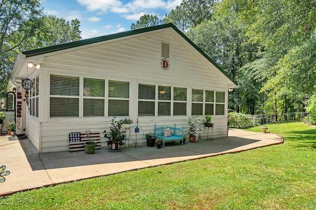 back of property with a lawn and a patio area