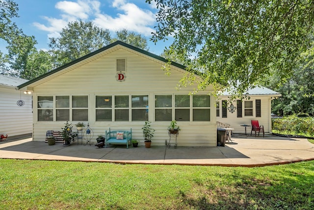 back of property with a yard and a patio area