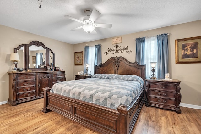 bedroom featuring ceiling fan, a textured ceiling, and light hardwood / wood-style flooring