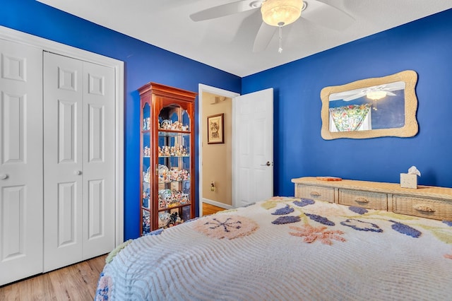 bedroom with ceiling fan, a closet, and wood-type flooring