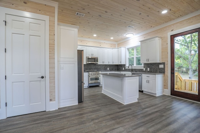 kitchen featuring appliances with stainless steel finishes, a kitchen island, wooden ceiling, white cabinetry, and plenty of natural light