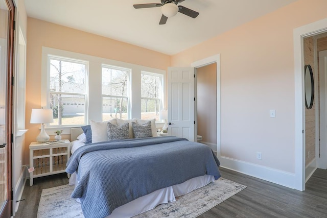 bedroom featuring dark wood-style floors, a ceiling fan, and baseboards