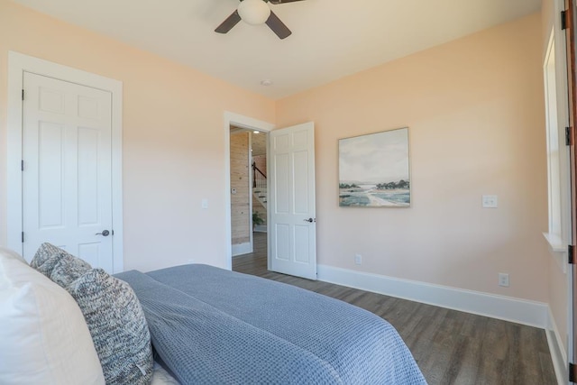 bedroom featuring ceiling fan, dark wood-type flooring, and baseboards