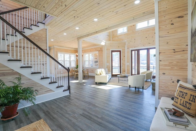 living area with a towering ceiling, stairs, wood finished floors, and wood ceiling