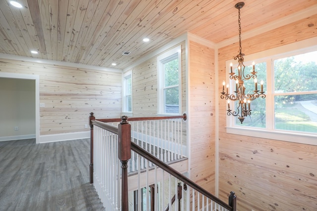 hall with wooden walls, wooden ceiling, dark hardwood / wood-style floors, and a notable chandelier