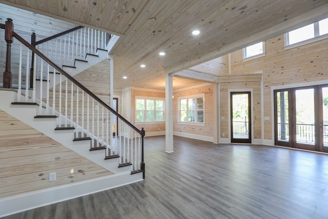 interior space with a high ceiling, a wealth of natural light, wooden walls, and wood ceiling