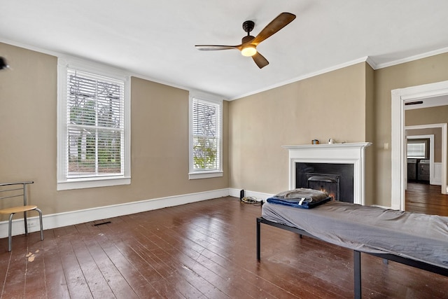 living room featuring dark wood-type flooring, ceiling fan, and crown molding