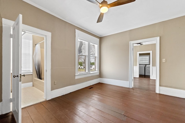 unfurnished bedroom featuring wood-type flooring, washer / dryer, and ornamental molding