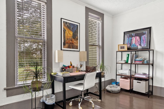 office area with dark wood-type flooring, ornamental molding, and a textured ceiling