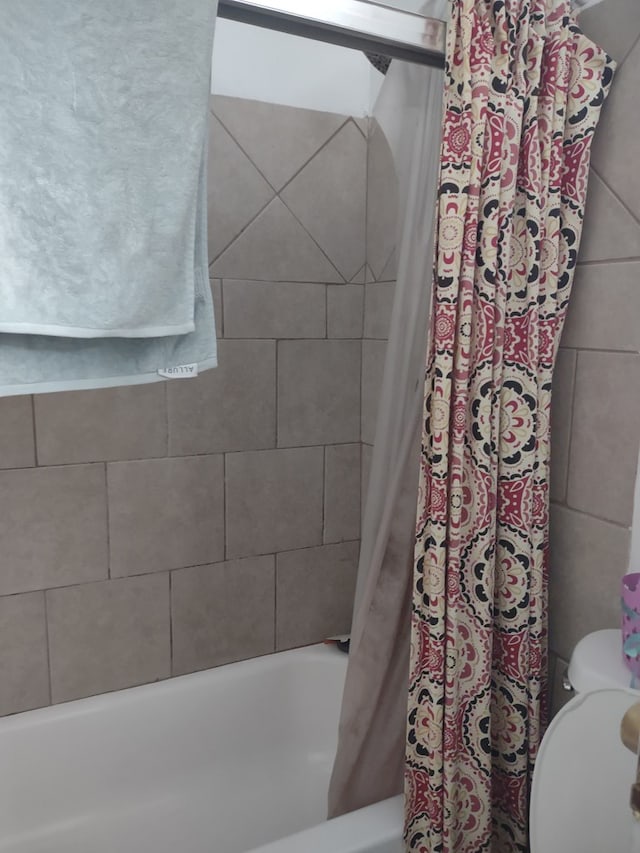 full bath featuring shower / tub combo and toilet