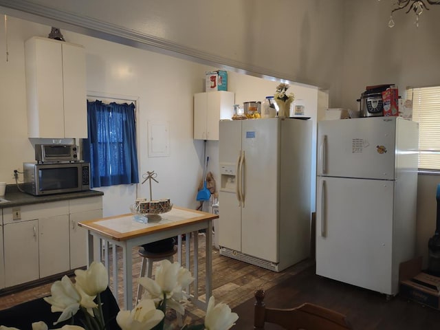 kitchen with white refrigerator with ice dispenser, stainless steel microwave, dark wood-type flooring, freestanding refrigerator, and white cabinetry